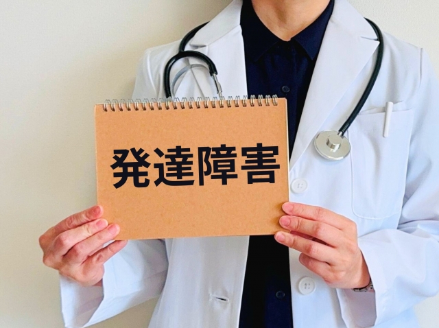 発達障害と書かれた紙をもつ医者