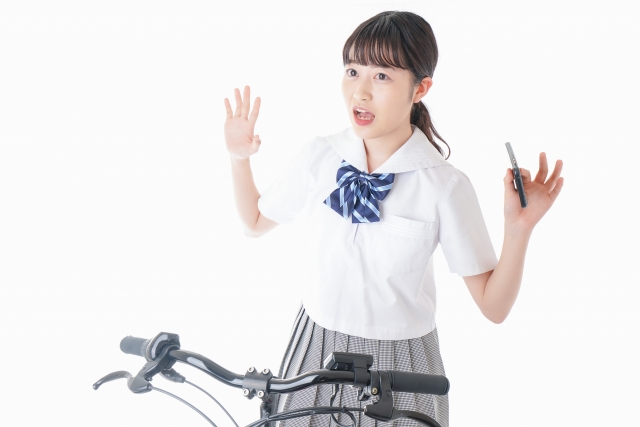 自転車に跨って驚く女子高生