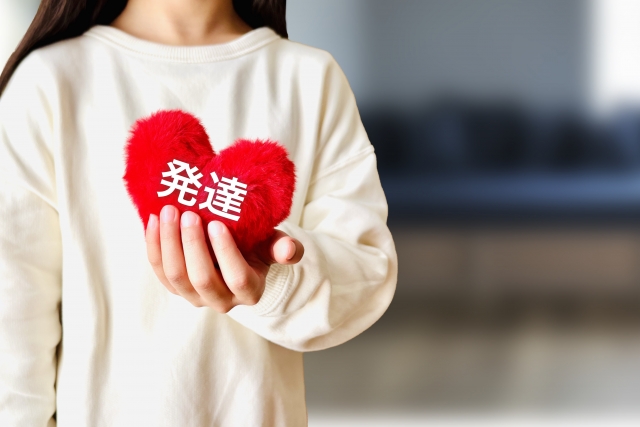 発達と書かれたハートを持っている女性