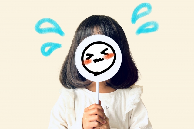 顔に絵をあてる女の子