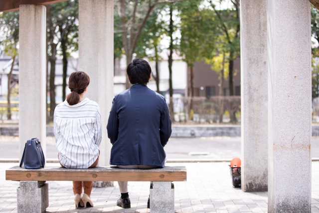 ベンチに座る夫婦の後ろ姿