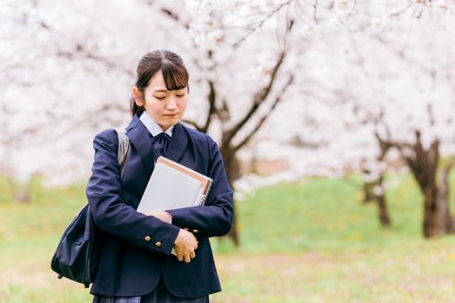 桜の下を歩く女子学生