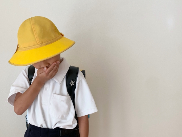 口を塞いでいる男の子