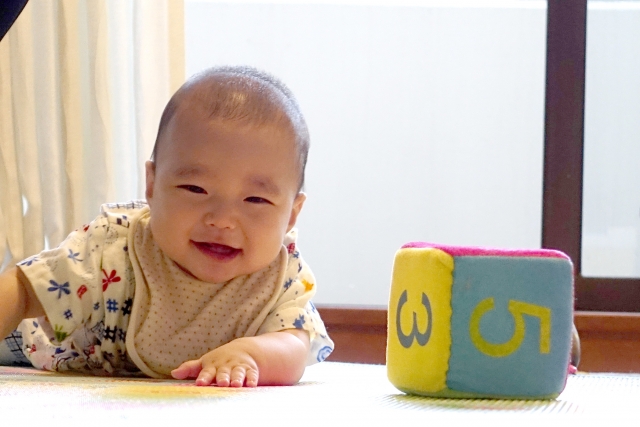 おもちゃの横で笑っている赤ちゃん