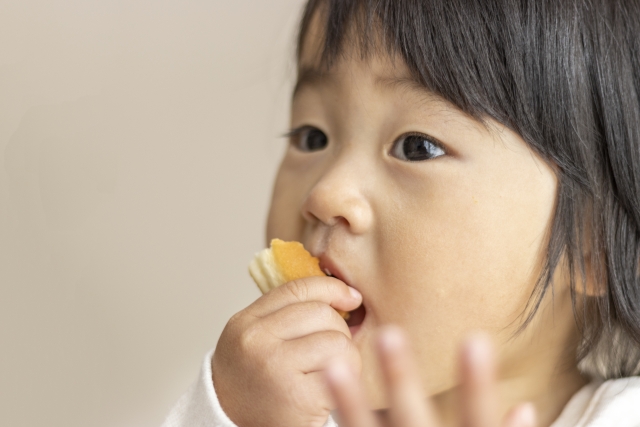 手掴みで食べる子供