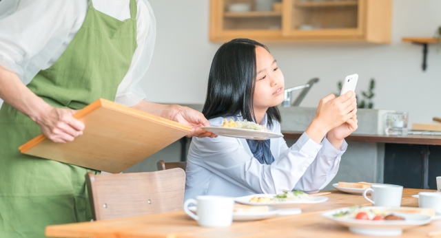 携帯に夢中な女子学生