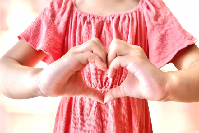 手でハートを作っている女性