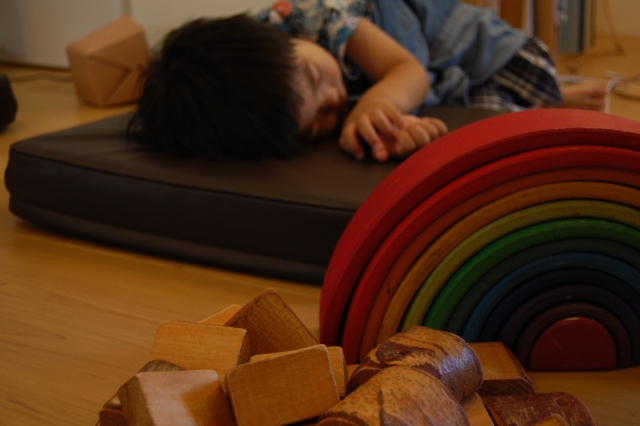 散らかった部屋で寝ている子供