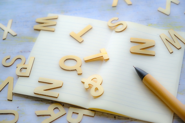 ノートの上に散らばるアルファベット