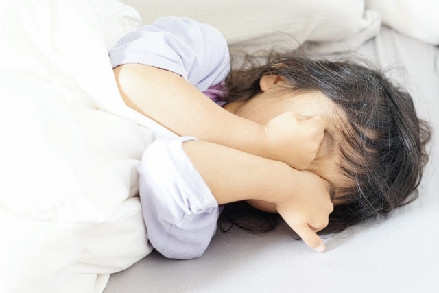 顔を隠して寝ている女の子