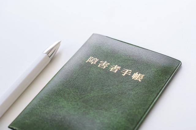 緑色の障害者手帳とペン