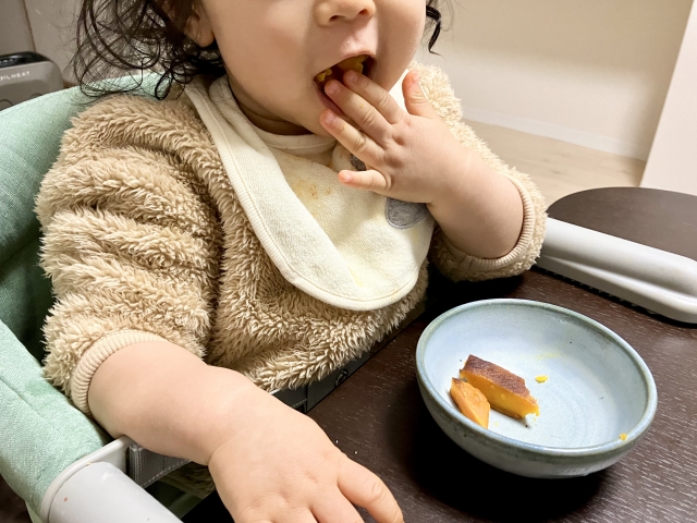 お菓子を手で食べている子供