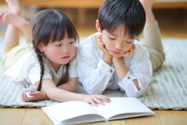 本を一緒に見ている子供たち