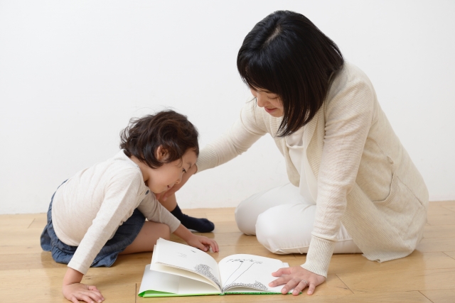 お母さんと絵本を読む女のこ