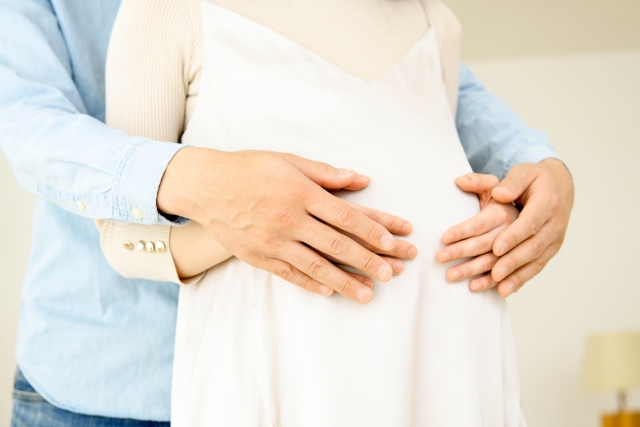 お腹をさする妊婦さんと旦那さん