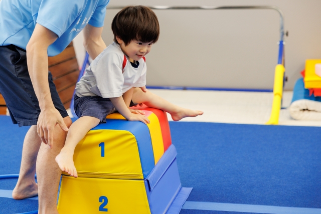 跳び箱を飛ぶ練習をする男の子