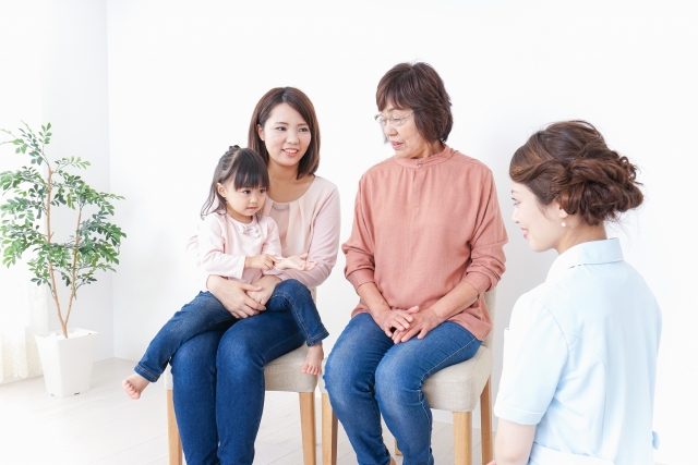 看護師の前に座っている 女性二人と子供