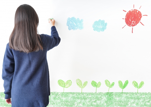 壁に可愛い絵を描く女の子