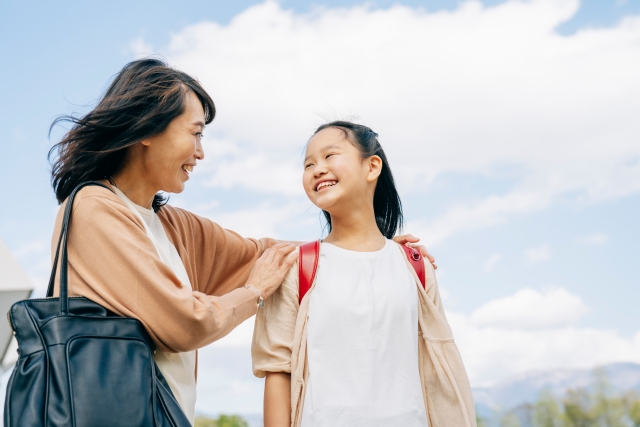 子供の背中を押すお母さん