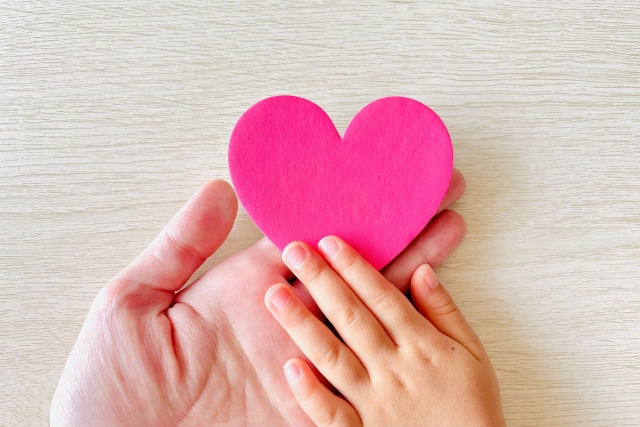 ハートを触る大人と子供の手