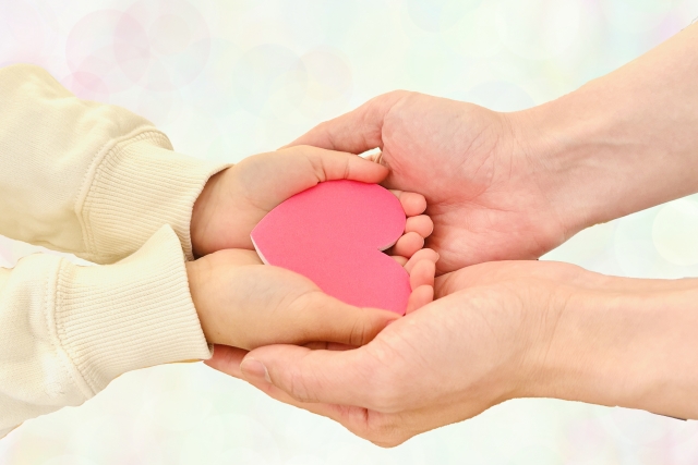 大人の手と子供の手とハート
