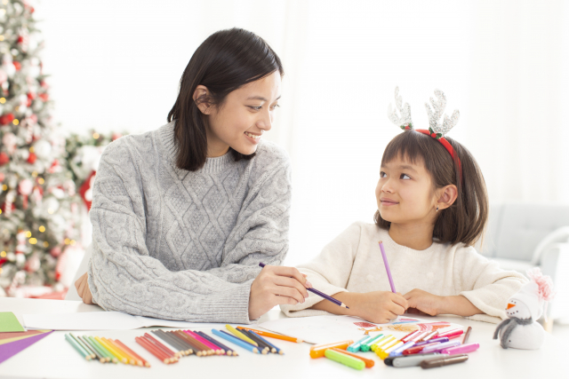 お母さんと塗り絵をしている子ども