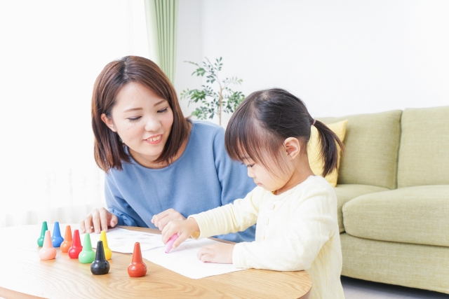 笑顔のお母さんと宿題をしている子供