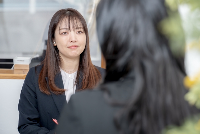 スーツを着て話を聞く女性