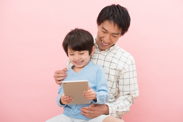 仲良くタブレットを見ている親子