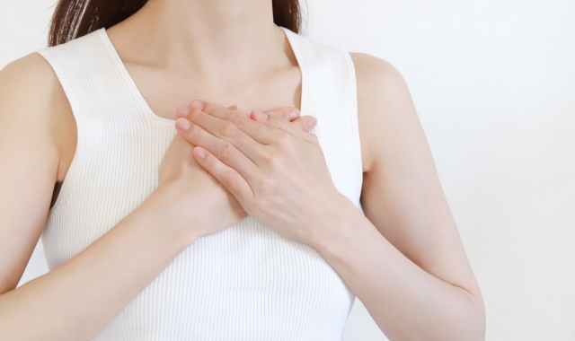 胸に手を当てる女性