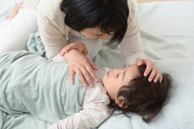 子供を寝かしつけるお母さん