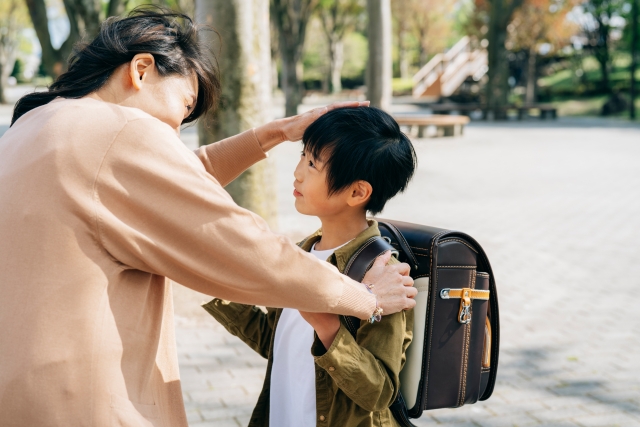 小学生の頭をヨシヨシするお母さん