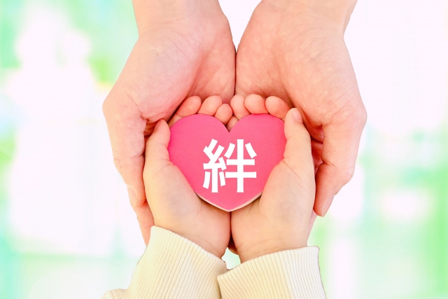 絆を包み込む子供と大人の手