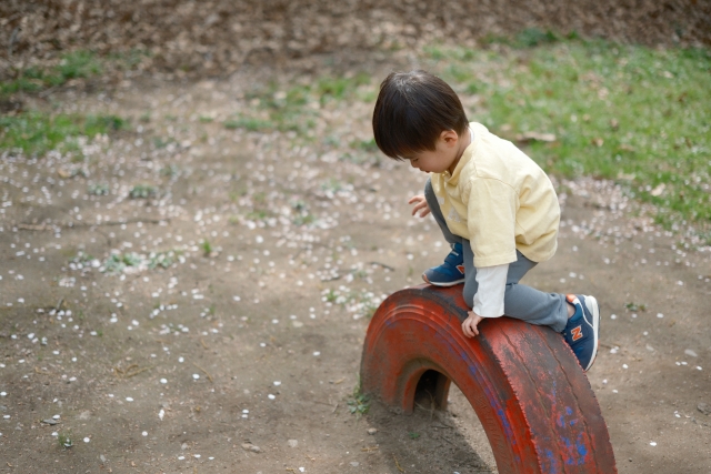 男の子がタイヤで遊んでいる写真