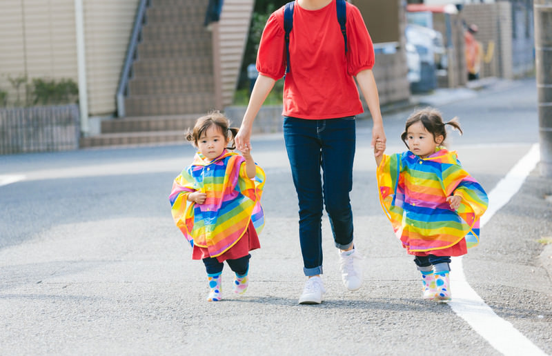 2人の子供がお母さんと手を繋いでいる写真