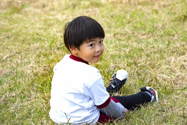 男の子が草原で座っている写真