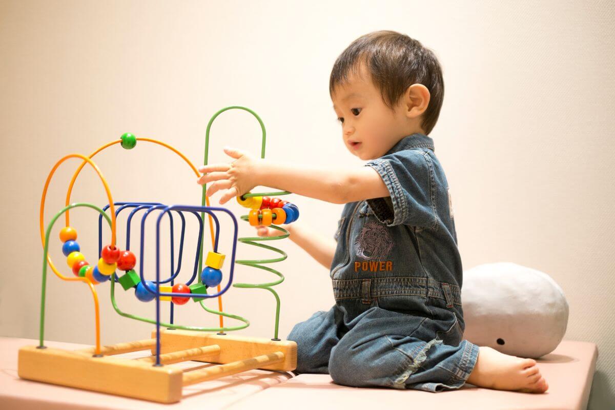 小さな男の子がおもちゃで遊んでいる様子。