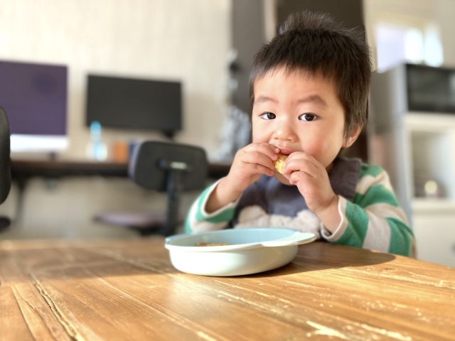 子供が自分でご飯を食べている写真