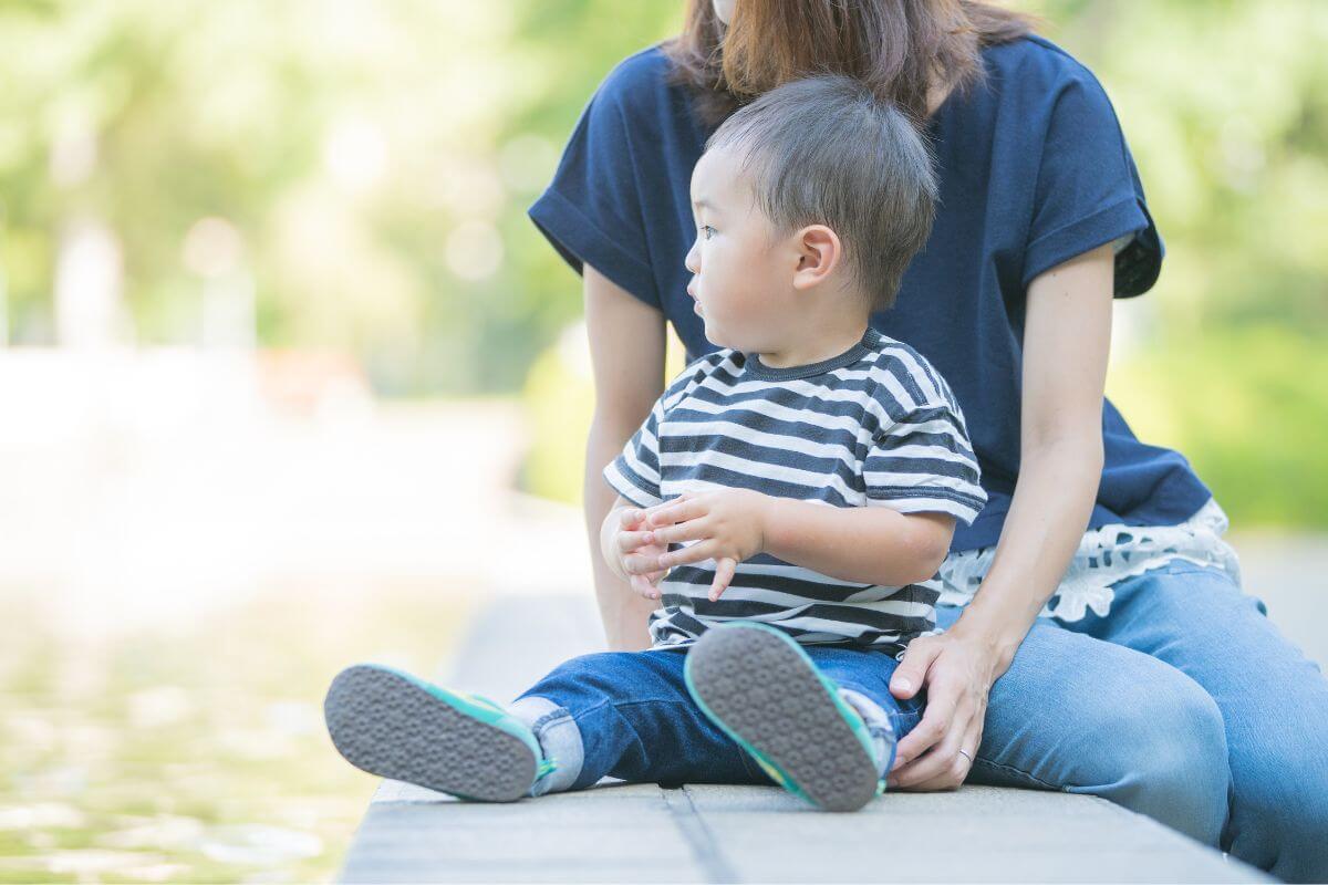 保護者が小さな男の子と座っている様子。