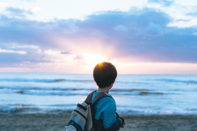 子どもが太陽を眺めている写真