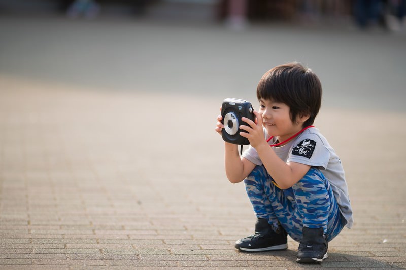 男の子がカメラで写真を撮っている写真