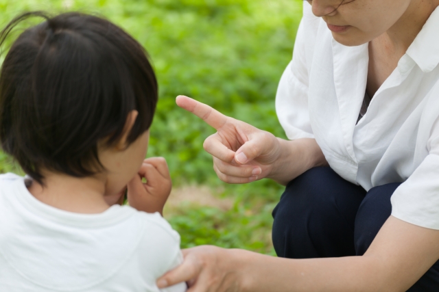 子供がお母さんに叱られている写真