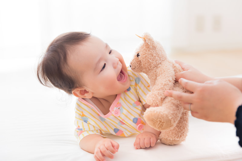 赤ちゃんがぬいぐるみで喜んでいる写真