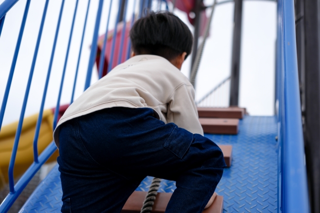 男の子が遊具で遊んでいる写真